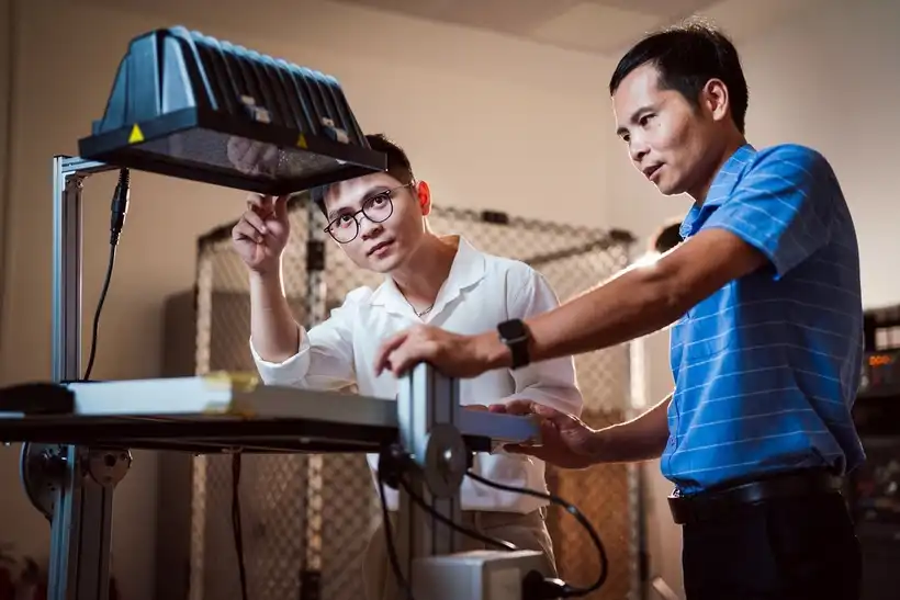 TS. Đỗ Danh Cường (áo xanh) - Trưởng nhóm nghiên cứu giới thiệu mô hình thí nghiệm về năng lượng mặt trời.